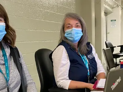 two masked staff members working at covid vaccine clinic