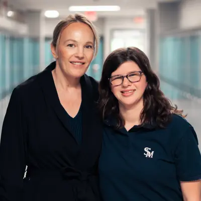 Teacher and student smiling, link to Vital Perspectives web page about belonging and health