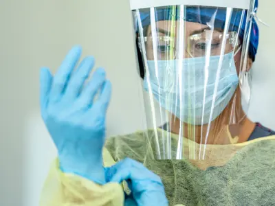 Nurse putting on PPE