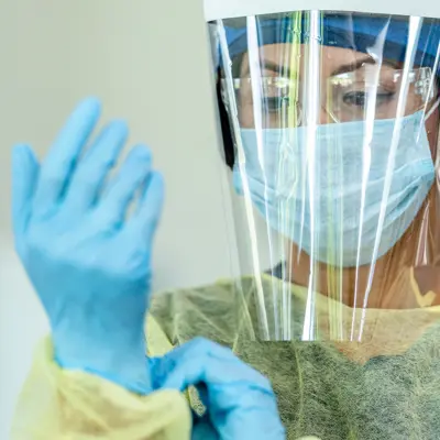 Nurse putting on PPE