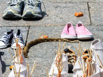 Photos of pairs of shoes. Each represents a child lost to the Indian Residential School System